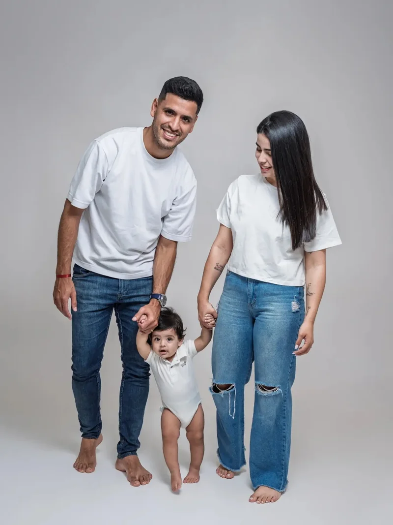 Familia caminando de la mano con su bebé en el estudio